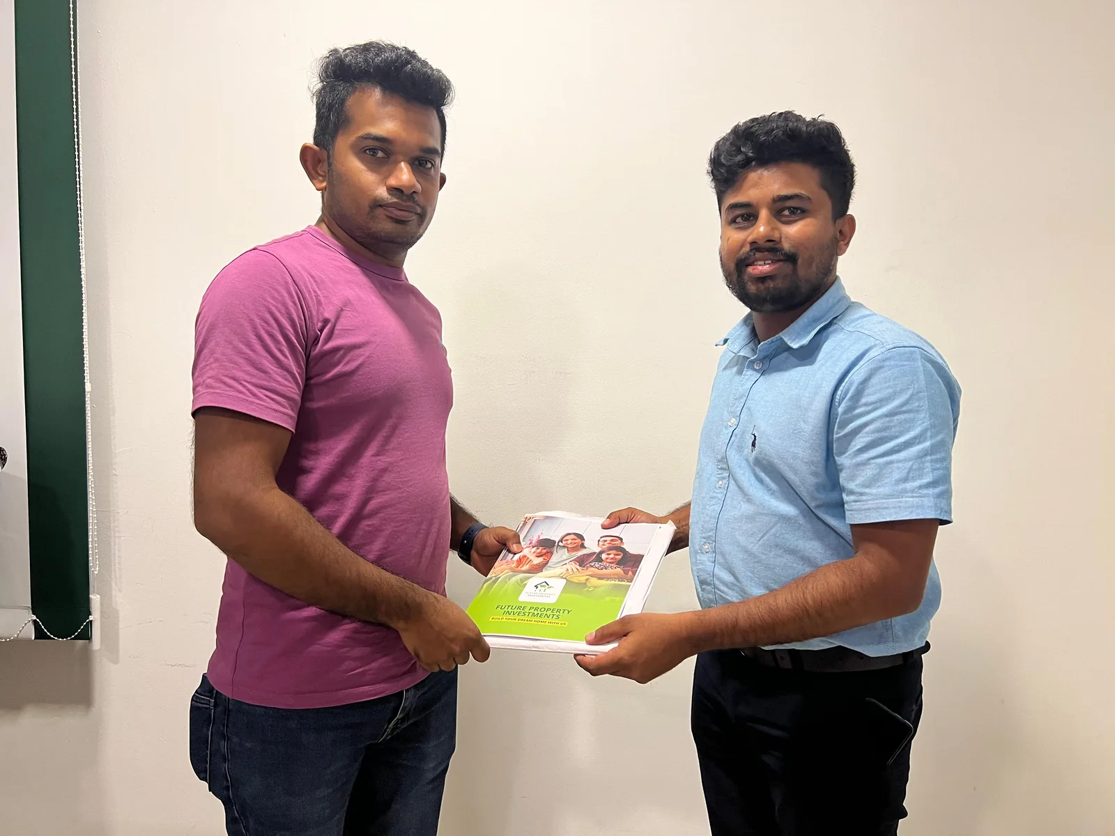 Structa staff member handing a property design document set to a client