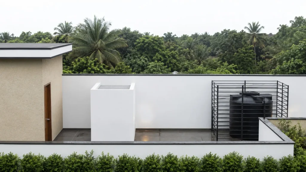 Roof terrace of the Kirushanthan residence with screened water tank, looking out over palm canopy